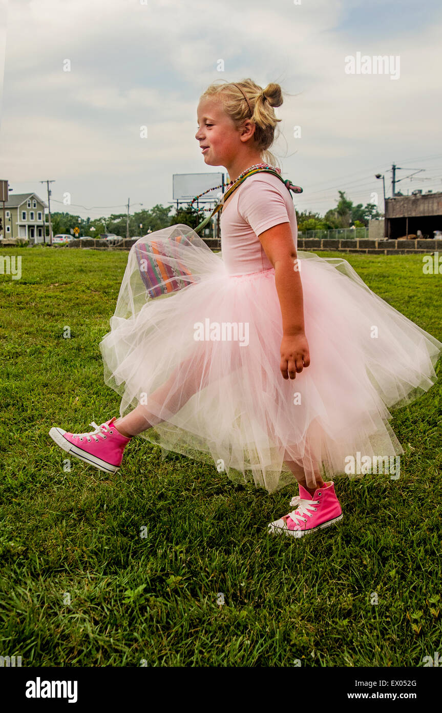 Niña vestidos de tutu y rosa botas de béisbol, caminando sobre el césped  Fotografía de stock - Alamy