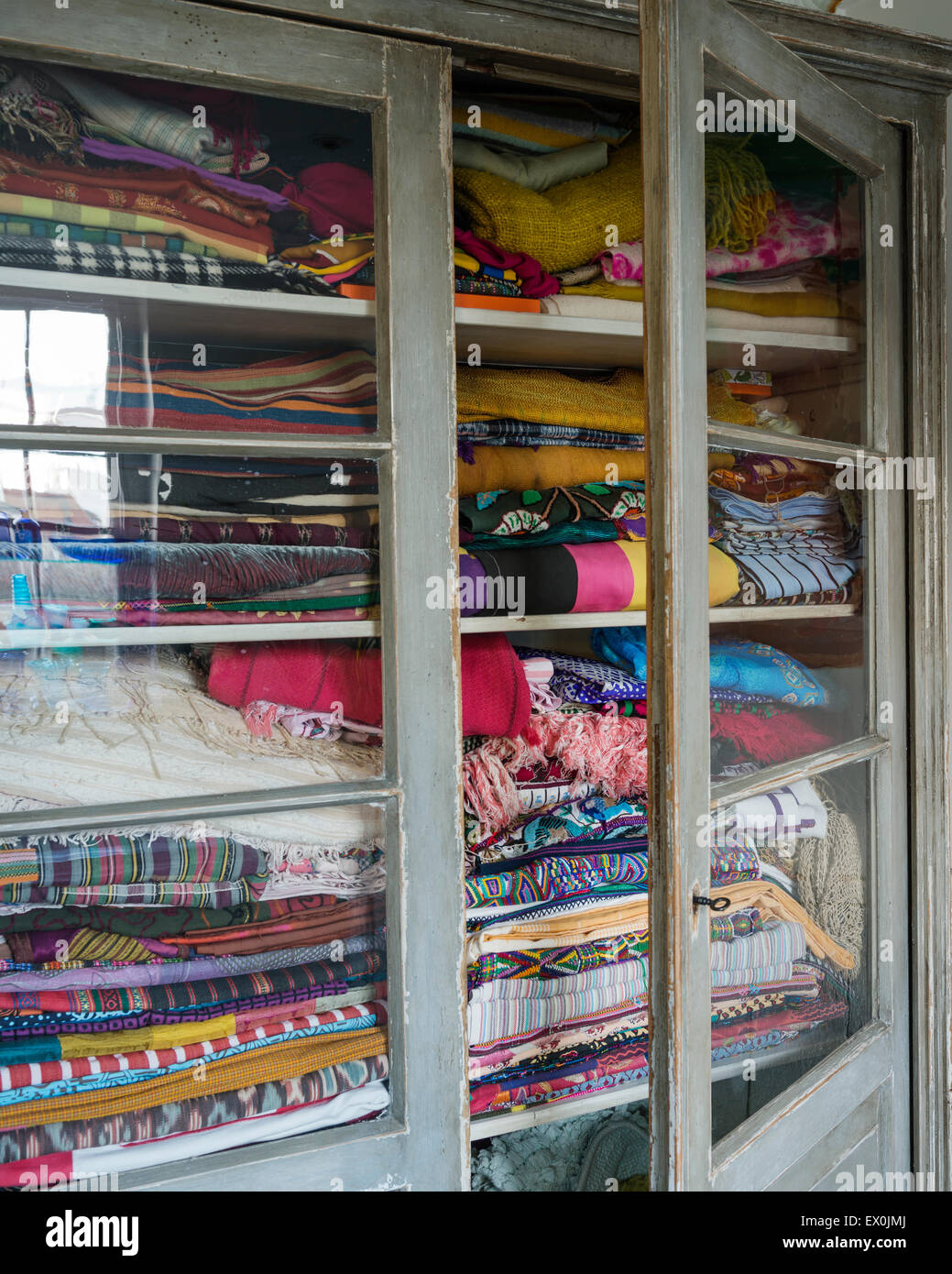 Armario de vidrio lleno de surtido de tejidos y textiles de todo el mundo Foto de stock