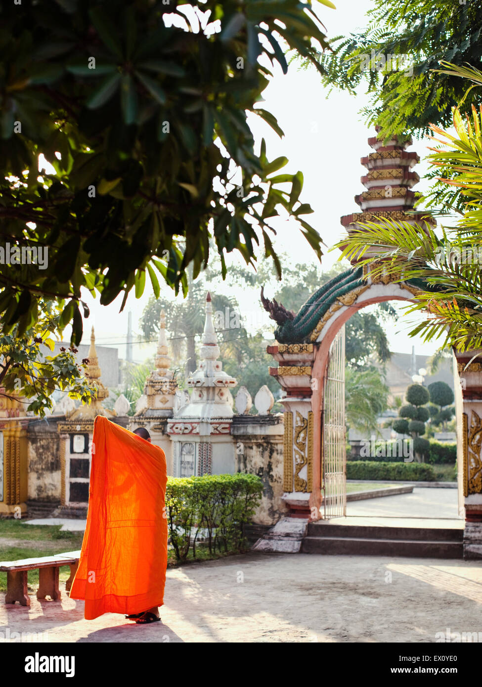 Un joven monje corrige su manto en Wat Si Muang, en Vientiane, Laos, P.D.R. Foto de stock