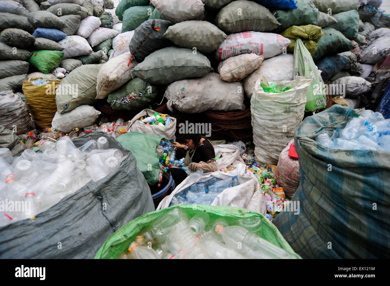 Un obrero recicla las botellas de plástico para la venta en un sitio de  reciclaje de botellas de plástico en Hefei，en la provincia de Anhui, 2 de  septiembre de 2009. VC Fotografía