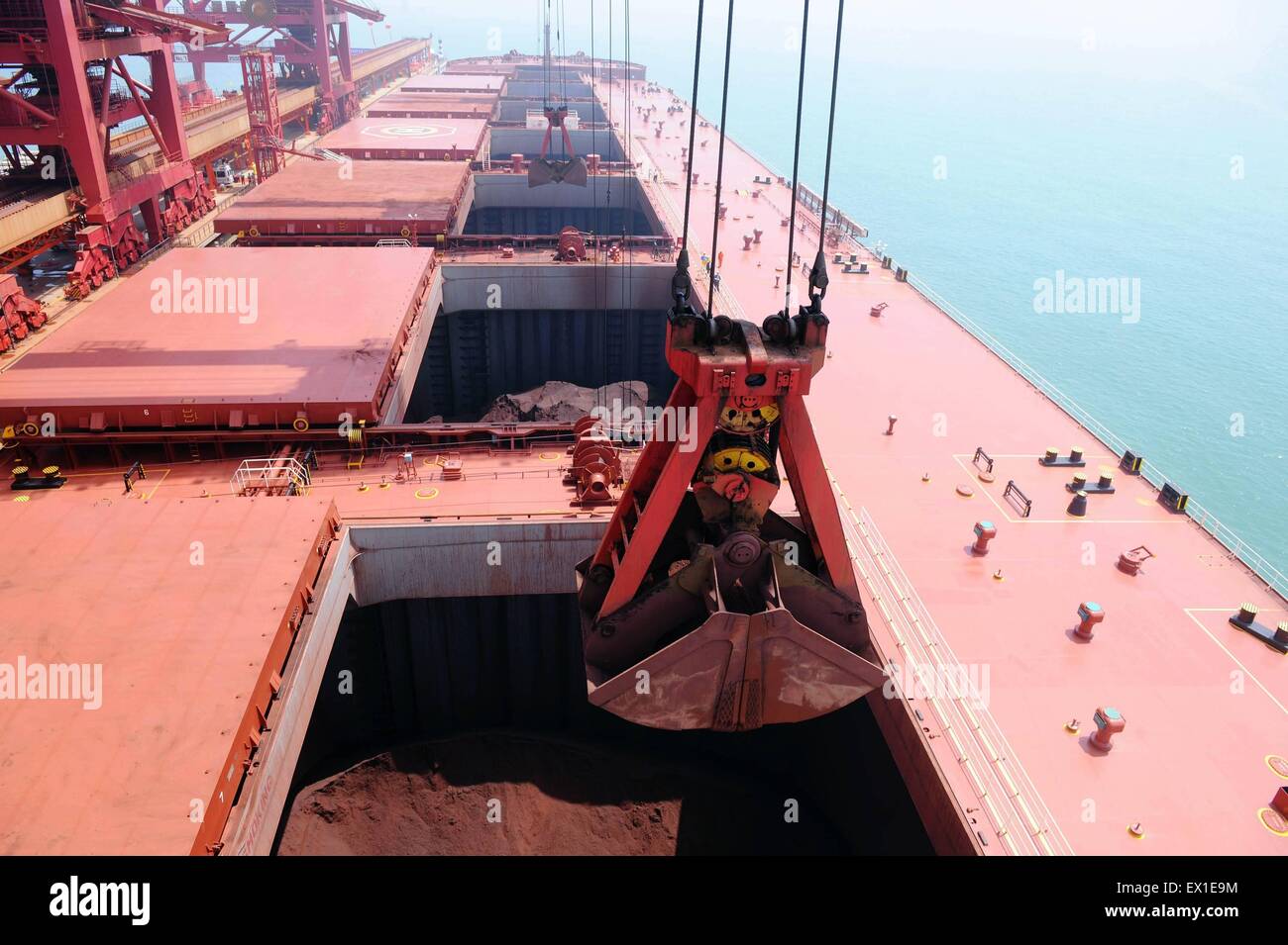 Qingdao, Provincia de Shandong, China. 4 de julio de 2015. Las grúas de descarga de mineral de hierro "Yuan Zhuo Hai', uno de los más grandes buques de mineral, en Dongjiakou dock en Qingdao, Provincia de Shandong, en el este de China, 4 de julio de 2015. El mineral de barco, con un peso muerto de 400.000 toneladas, anclado en el puerto de China por primera vez el sábado. © Yu Fangping/Xinhua/Alamy Live News Foto de stock