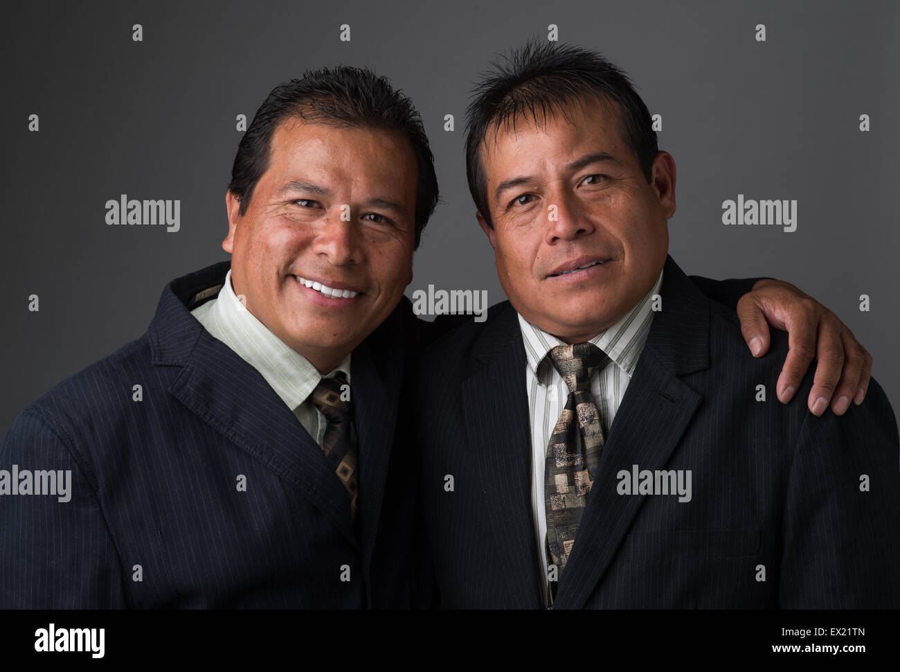 Hispanic Business hombres sonrientes vestidos de traje y corbata de negocios, posando para un retrato Foto de stock