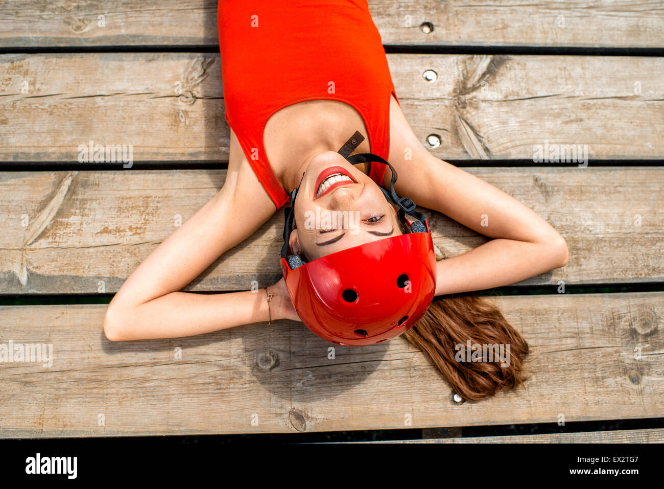 Mujer en ropa deportiva descansando sobre los tablones de madera Foto de stock