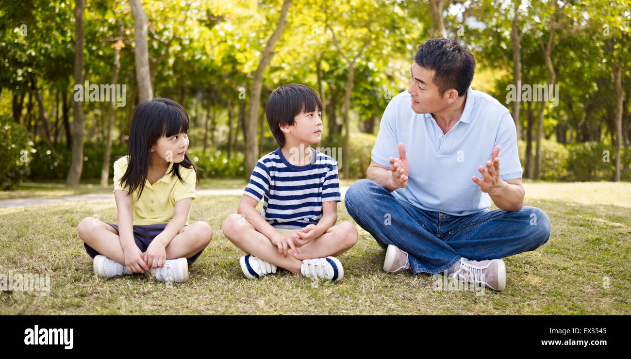 Padre de Asia y los niños se divierten en el parque Foto de stock