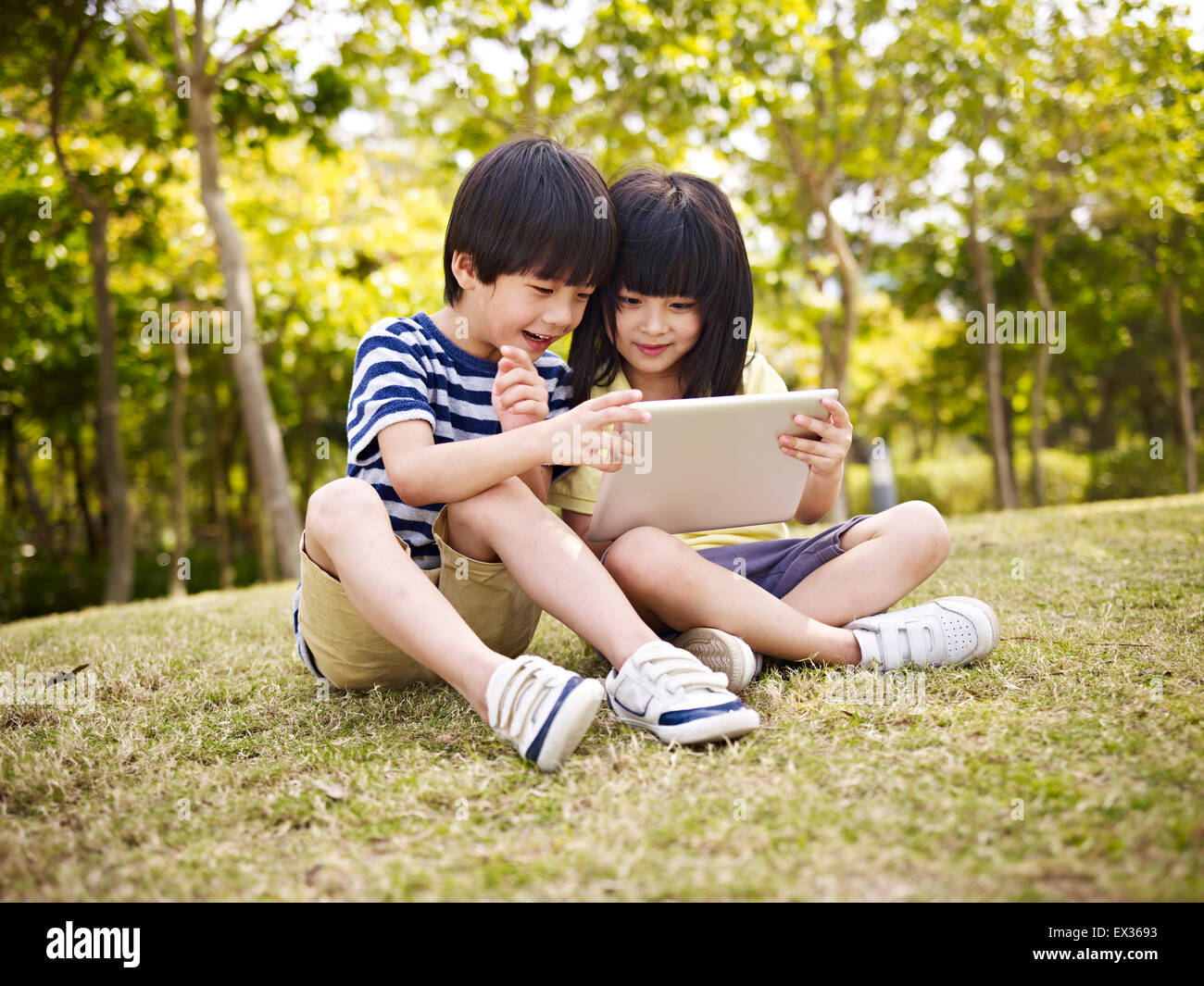 Los niños con ipad en el exterior Foto de stock