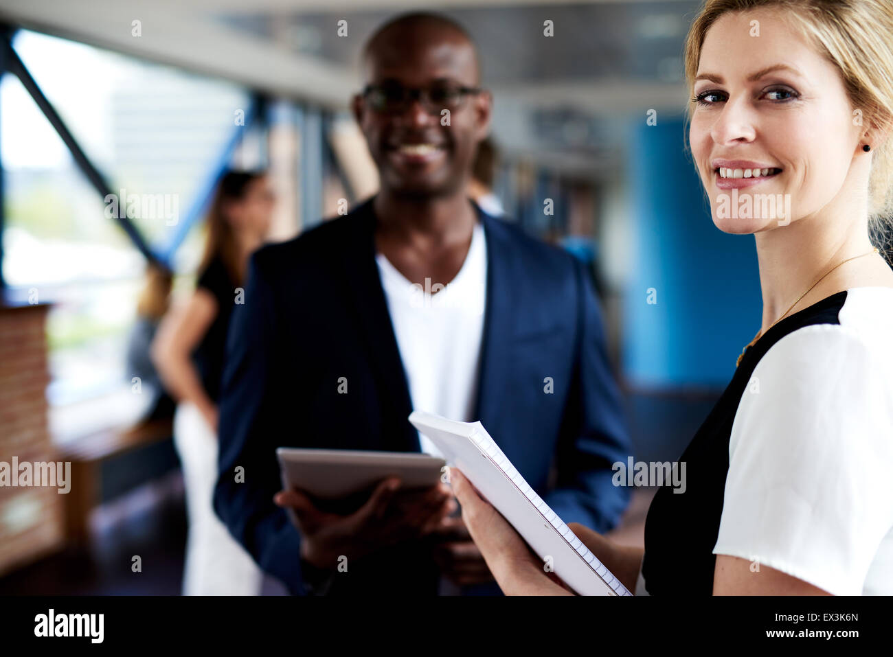 Macho negro y blanco ejecutivo ejecutivo femenino juntos y sonriendo a la cámara Foto de stock