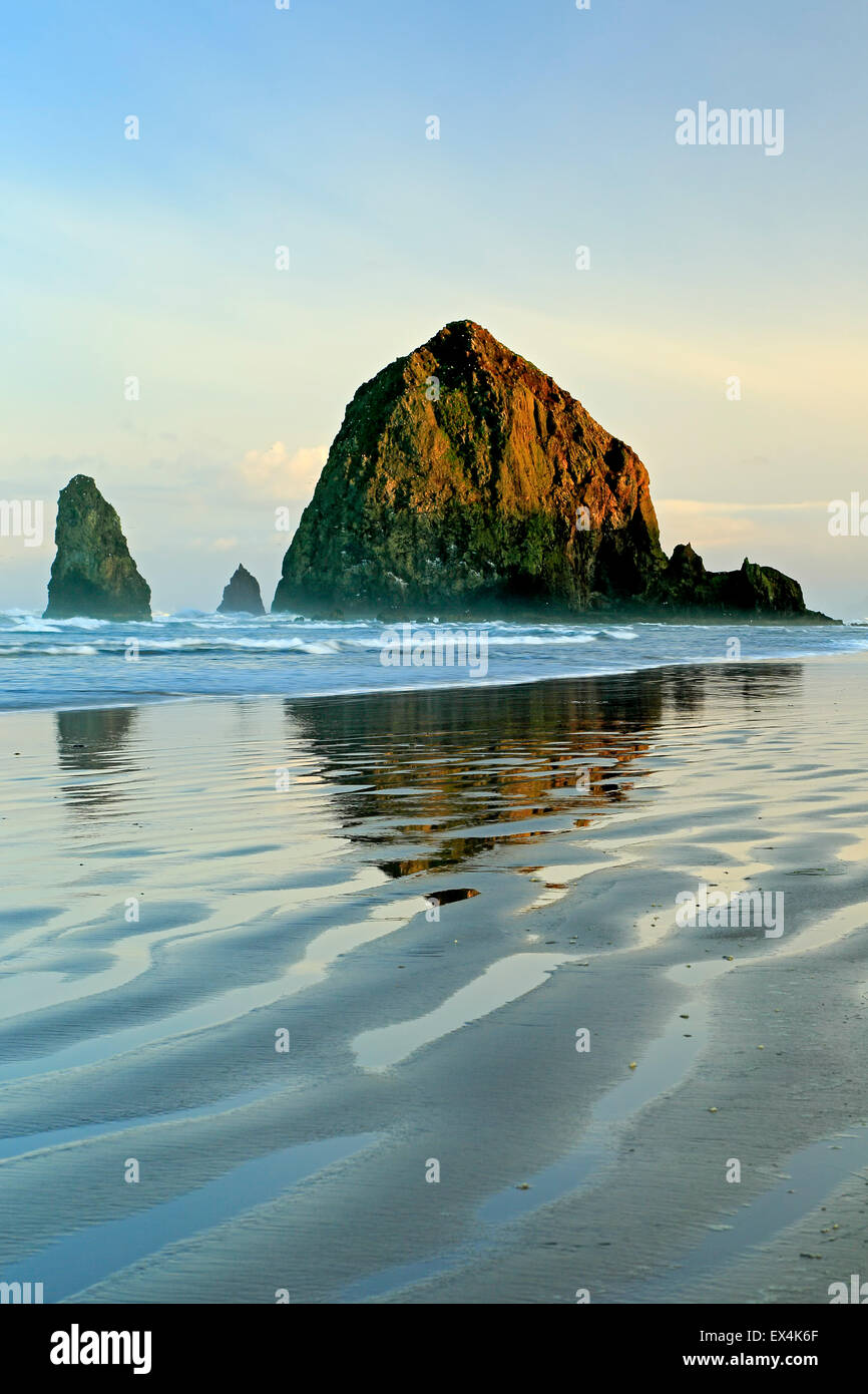 Haystack Rock reflejada en el agua y ondulaciones, Cannon Beach, Oregon, EE.UU. Foto de stock