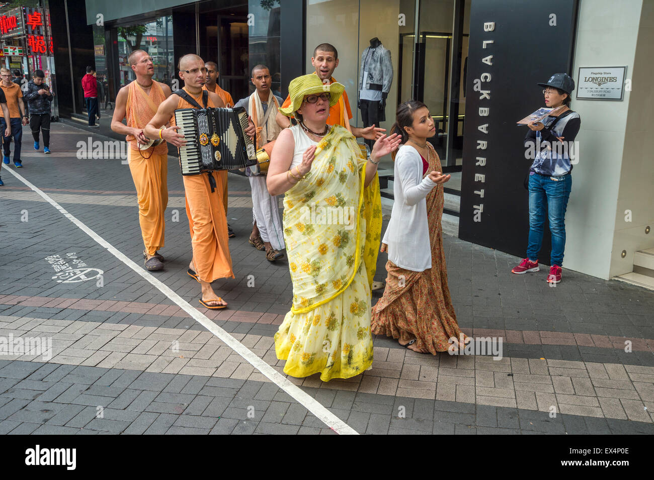 Devotos de Hare Krishna tocando y cantando en la calle, en Hong Kong, China Foto de stock