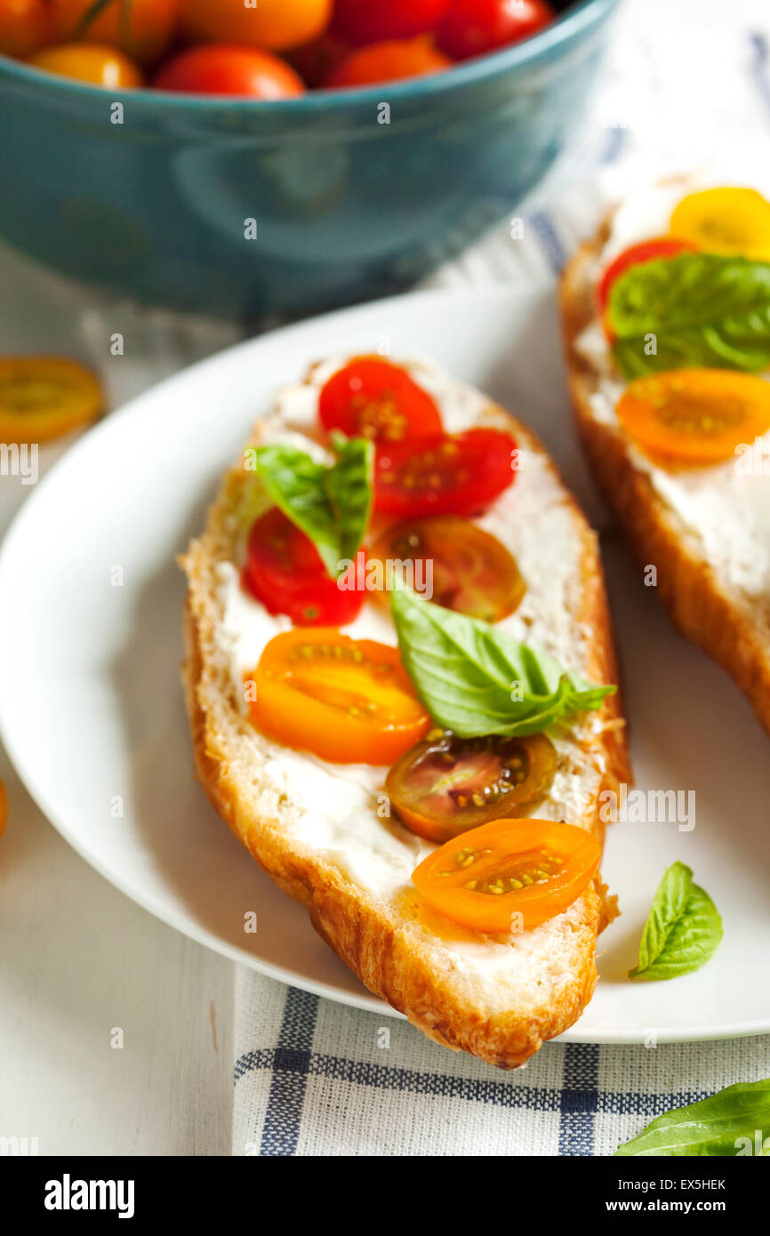 Croissant con tomate, albahaca y queso crema Foto de stock