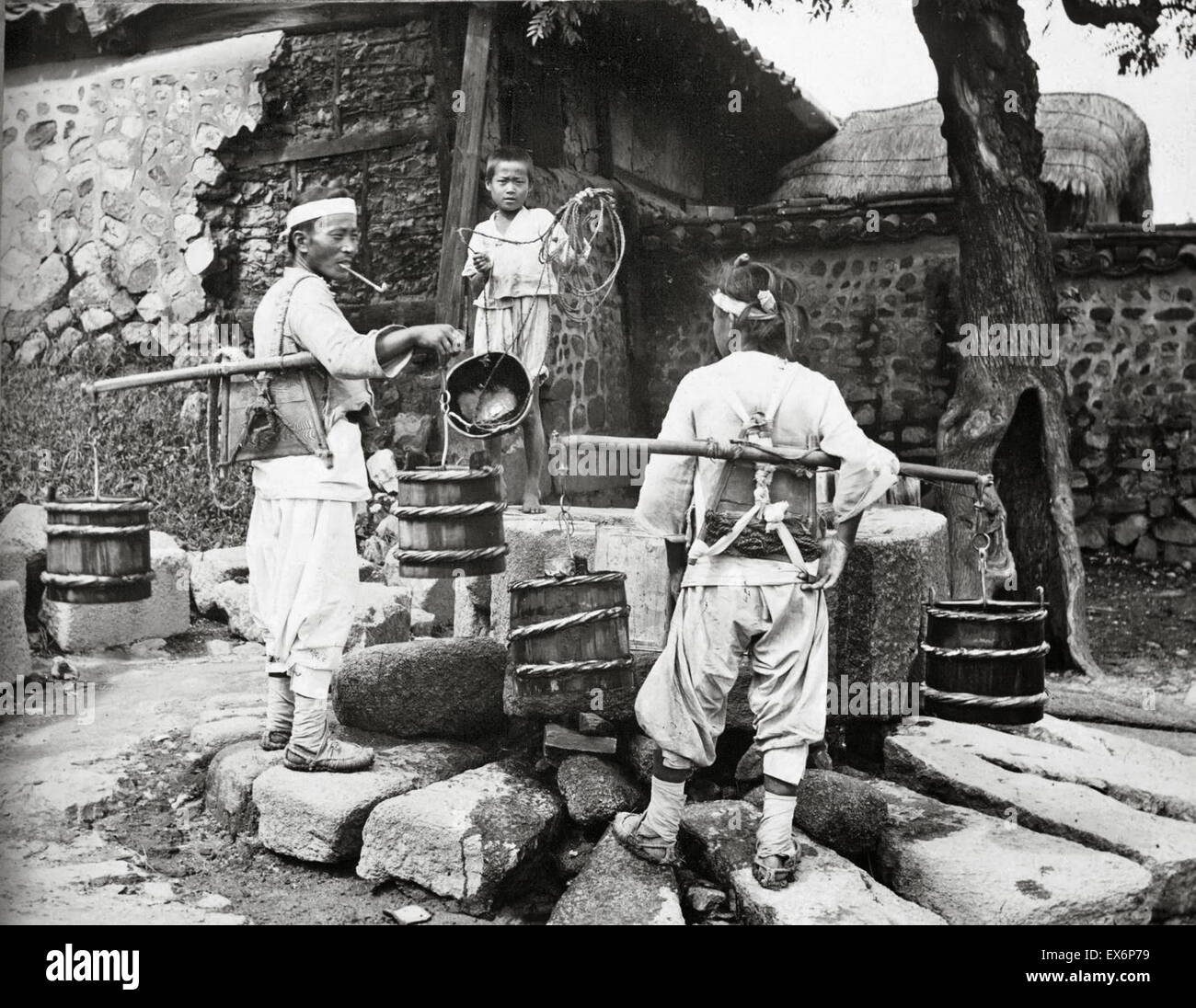 Portador de agua visitas una aldea, Corea 1904 Foto de stock