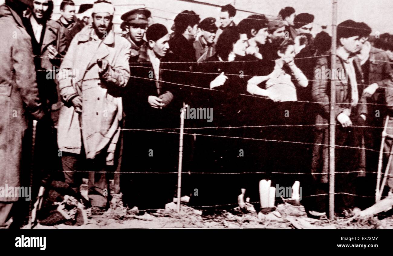 Refugiados republicanos españoles (militares y civiles) mirando desde detrás de alambre de púas, en un campamento de detención en Francia después de los Nacionalistas apoderarse de España en 1939 tras el final de la Guerra Civil Española. Foto de stock