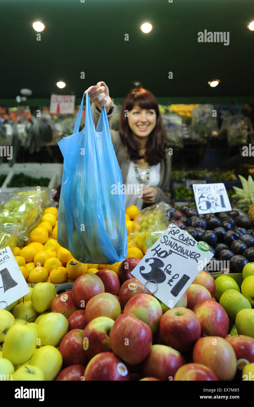 Una mujer de manos en una bolsa de fruta y verduras en un puesto en el mercado. Foto de stock