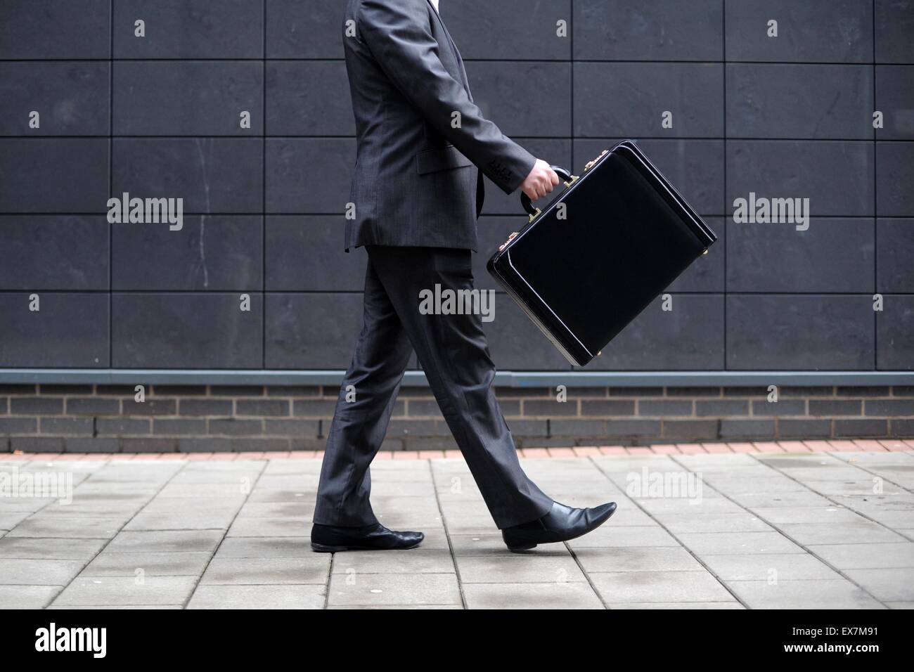 Un hombre de negocios lleva un maletín en el camino al trabajo en una oficina. Foto de stock
