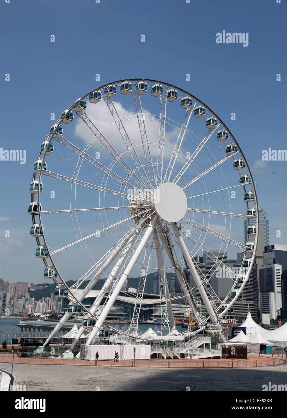Es una foto de una rueda grande para el entretenimiento y gran vista sobre el puerto de Hong Kong. Es como el ojo de Londres, pero en HK Foto de stock