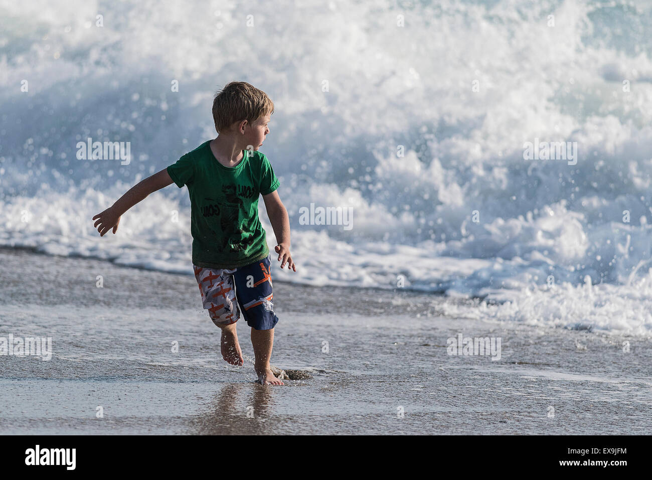 Un joven jugando en el mar, en la playa Fistral en Newquay, Cornwall. Foto de stock