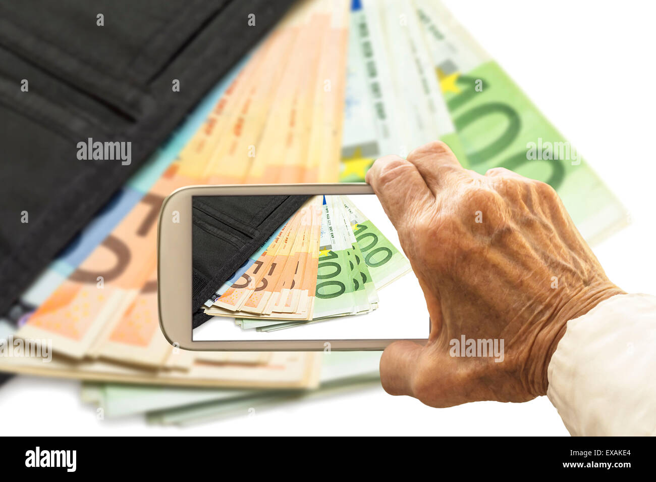 Vieja mano toma una foto de billetera con billetes en el teléfono inteligente. El enfoque selectivo. Foto de stock