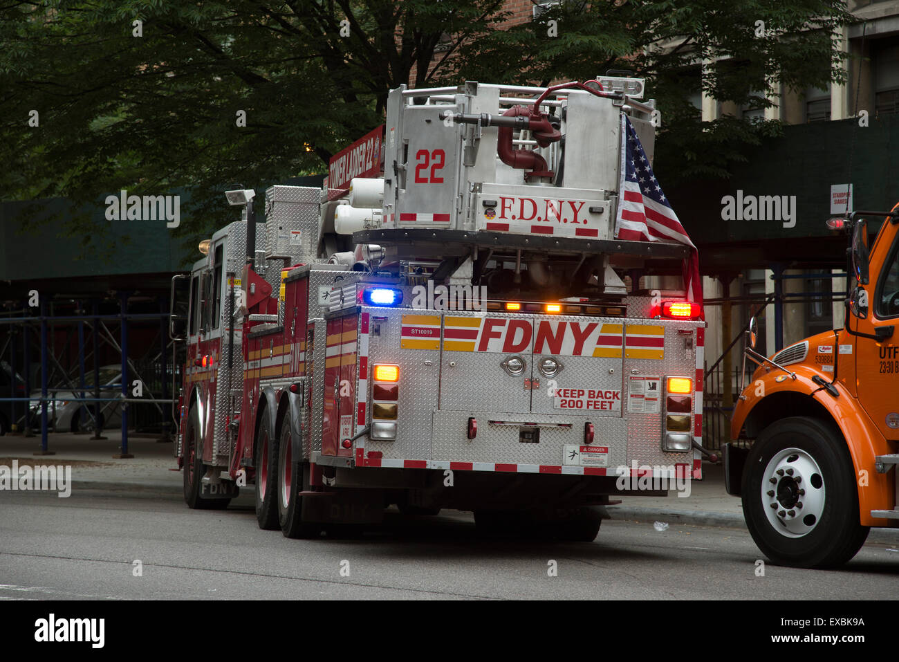 Escalera de la torre vista trasera de un camión de bomberos con bandera de Manhattan, Nueva York, EE.UU. Foto de stock