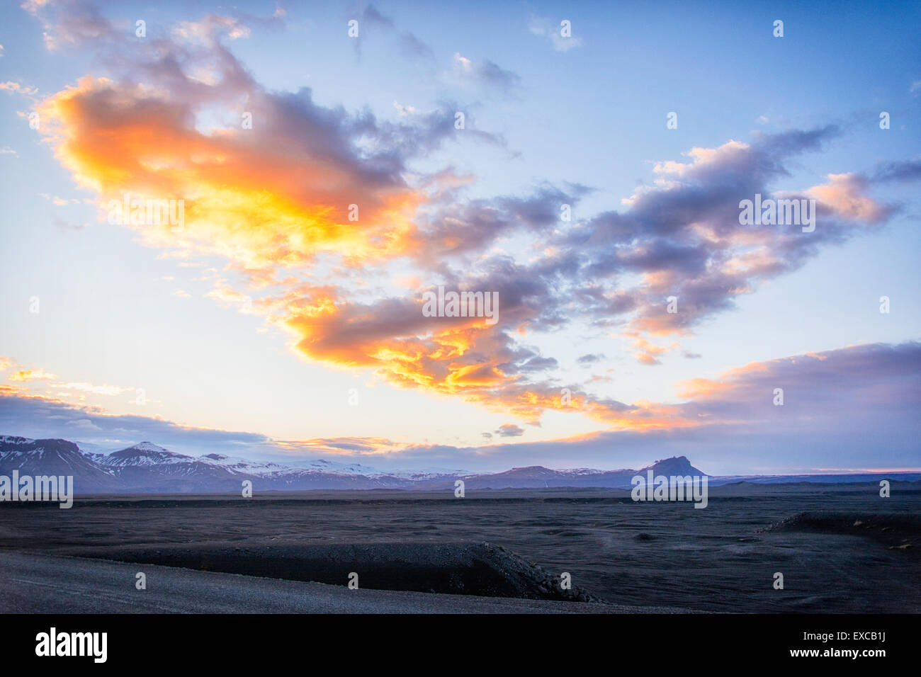 Puesta de sol sobre la arena negra yermos de Islandia Foto de stock