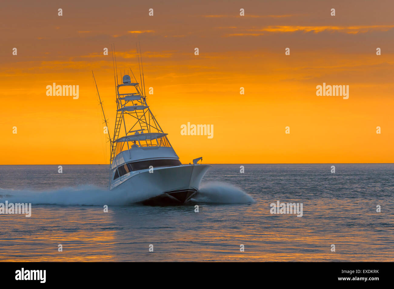 Cabib Cruiser Power Boat en el Golfo de México con un colorido atardecer cielo en segundo plano. Foto de stock