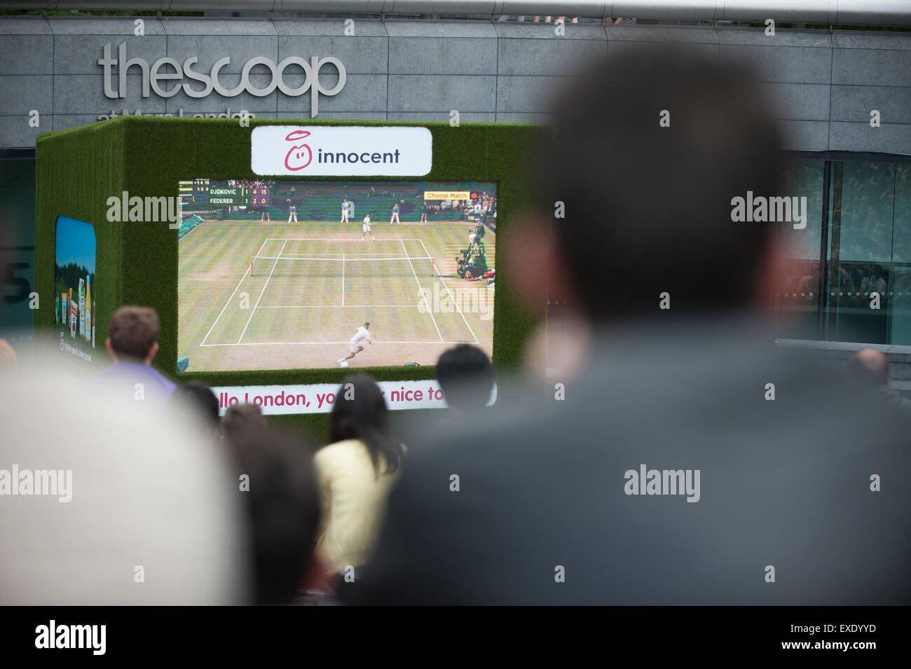 Londres, Reino Unido. El 12 de julio de 2015. La gente mira una pantalla gigante en el exterior, cerca del Ayuntamiento, mostrando la final masculina de Wimbledon 2015 entre Novak Djokovic y Roger Federer. Crédito: Stephen Chung / Alamy Live News Foto de stock