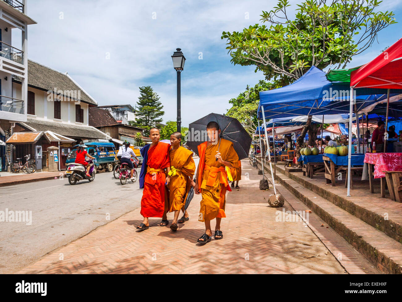 La República Democrática Popular Lao, Laos, Luang Prabang, monje budista novicios pasando el mercado en Sisavangvong carretera Foto de stock