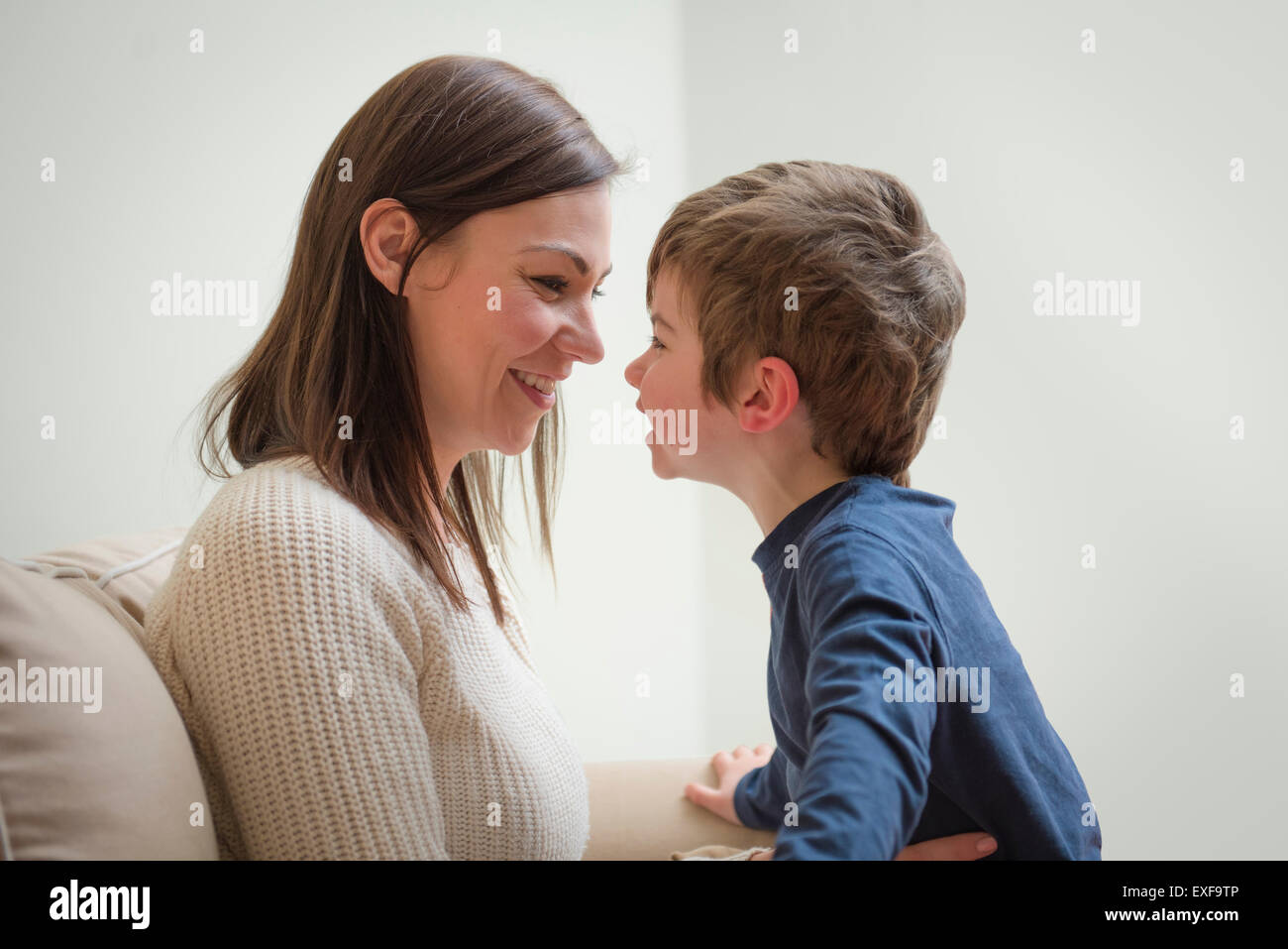 Madre e hijo sonriendo el uno al otro, cara a cara. Foto de stock