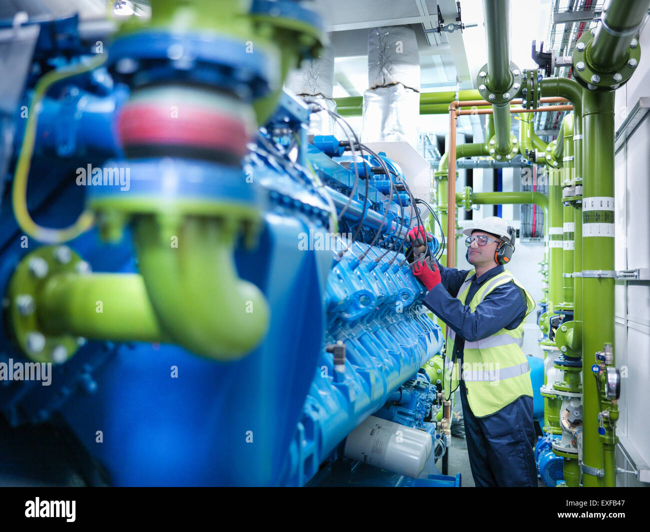 Trabajador con generador de gas en la central eléctrica alimentada con gas Foto de stock
