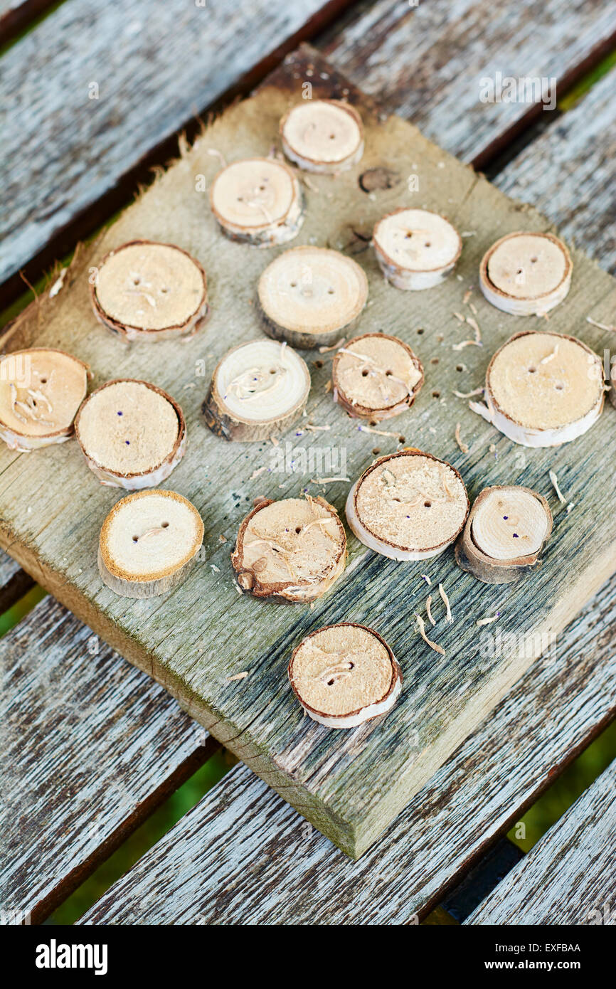 Botones de madera sobre un trozo de madera. Foto de stock