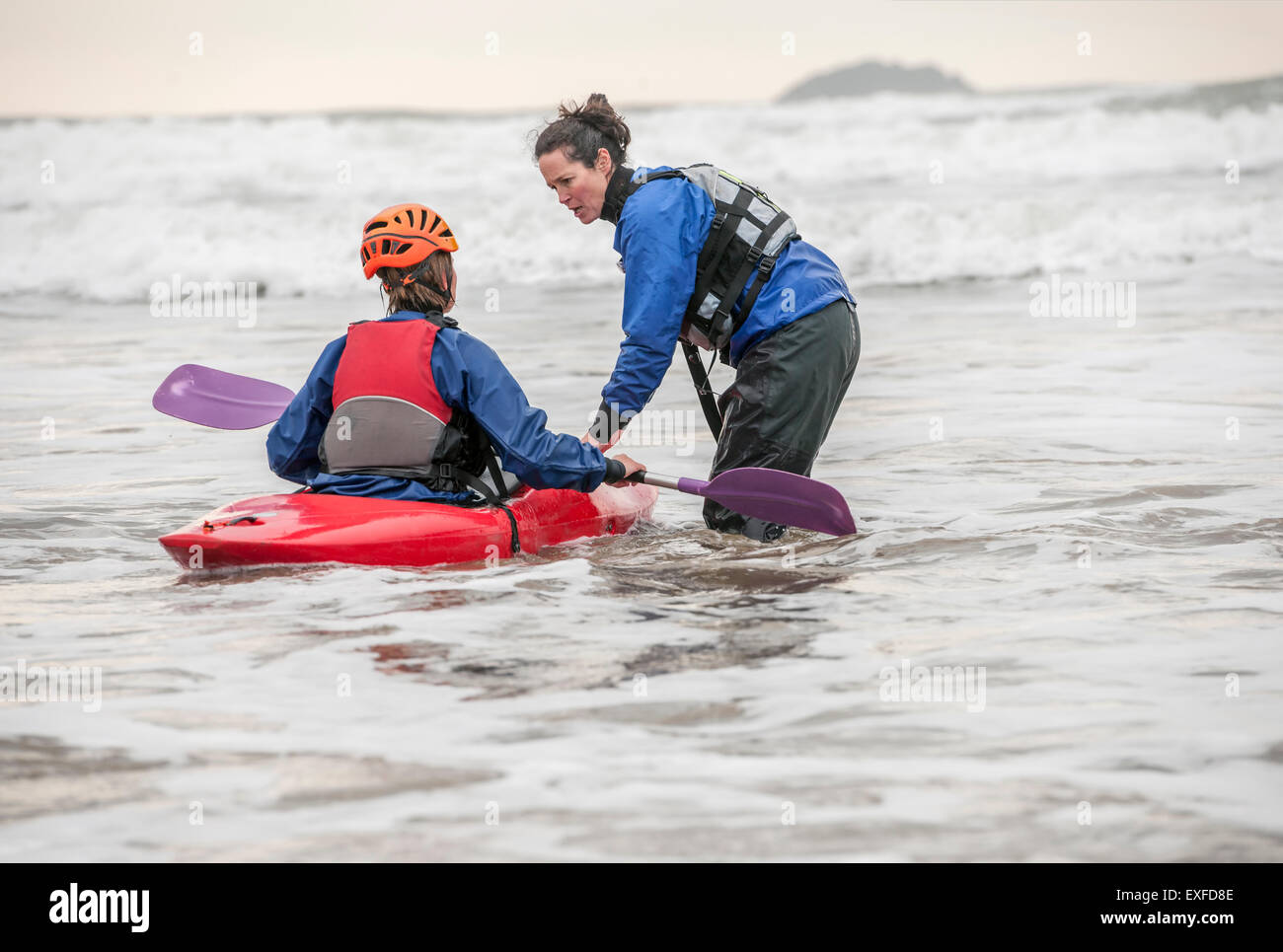 Instructora de ayudar a la mujer en kayak de mar Foto de stock