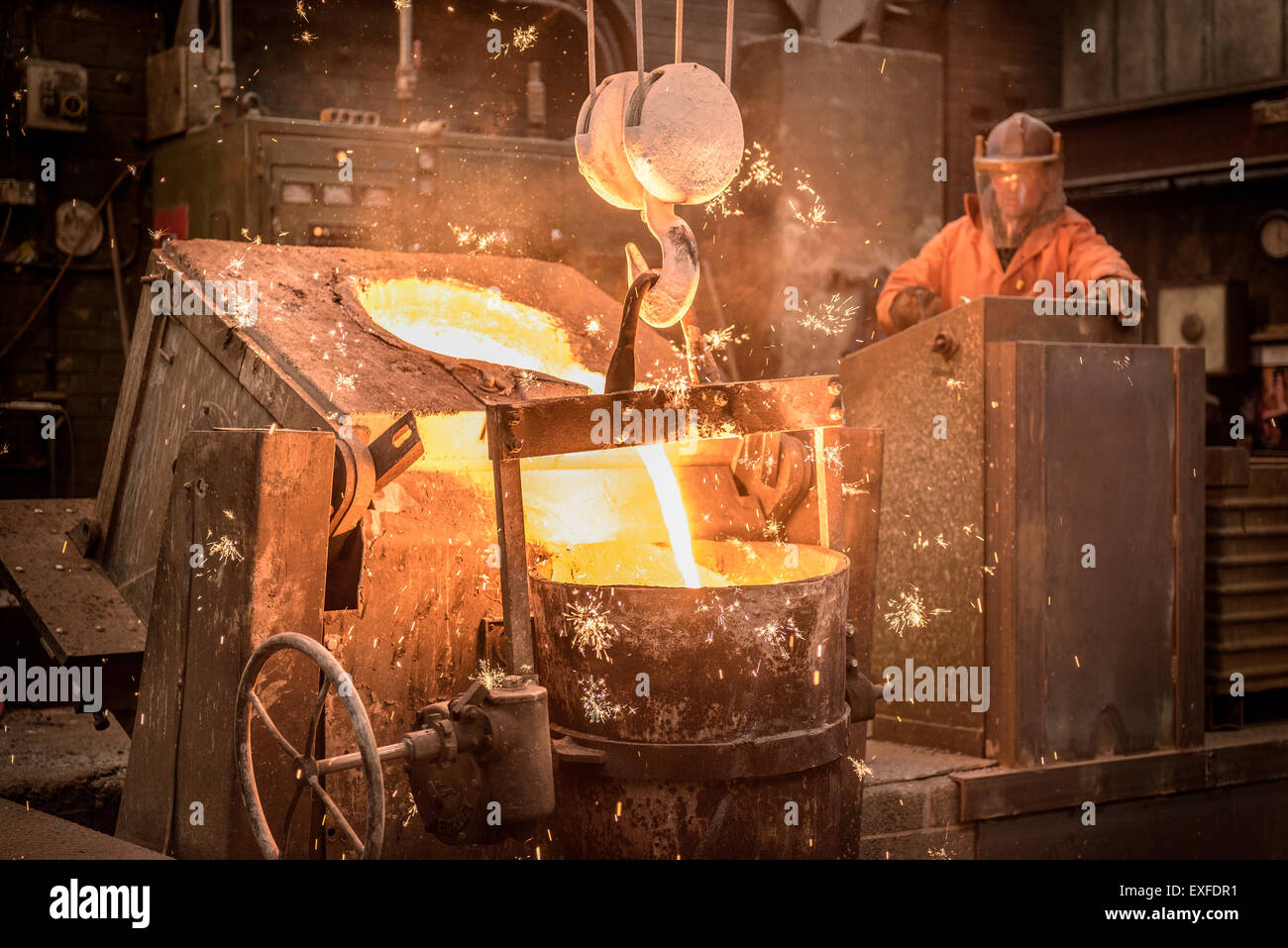 Trabajador vertiendo el metal fundido en la fundición Foto de stock