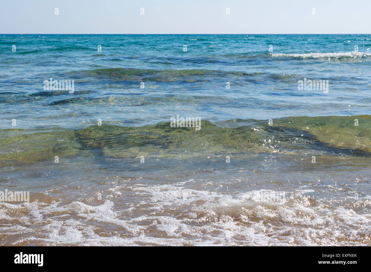 Pequeñas olas aumentando en mar azul cristalino Foto de stock