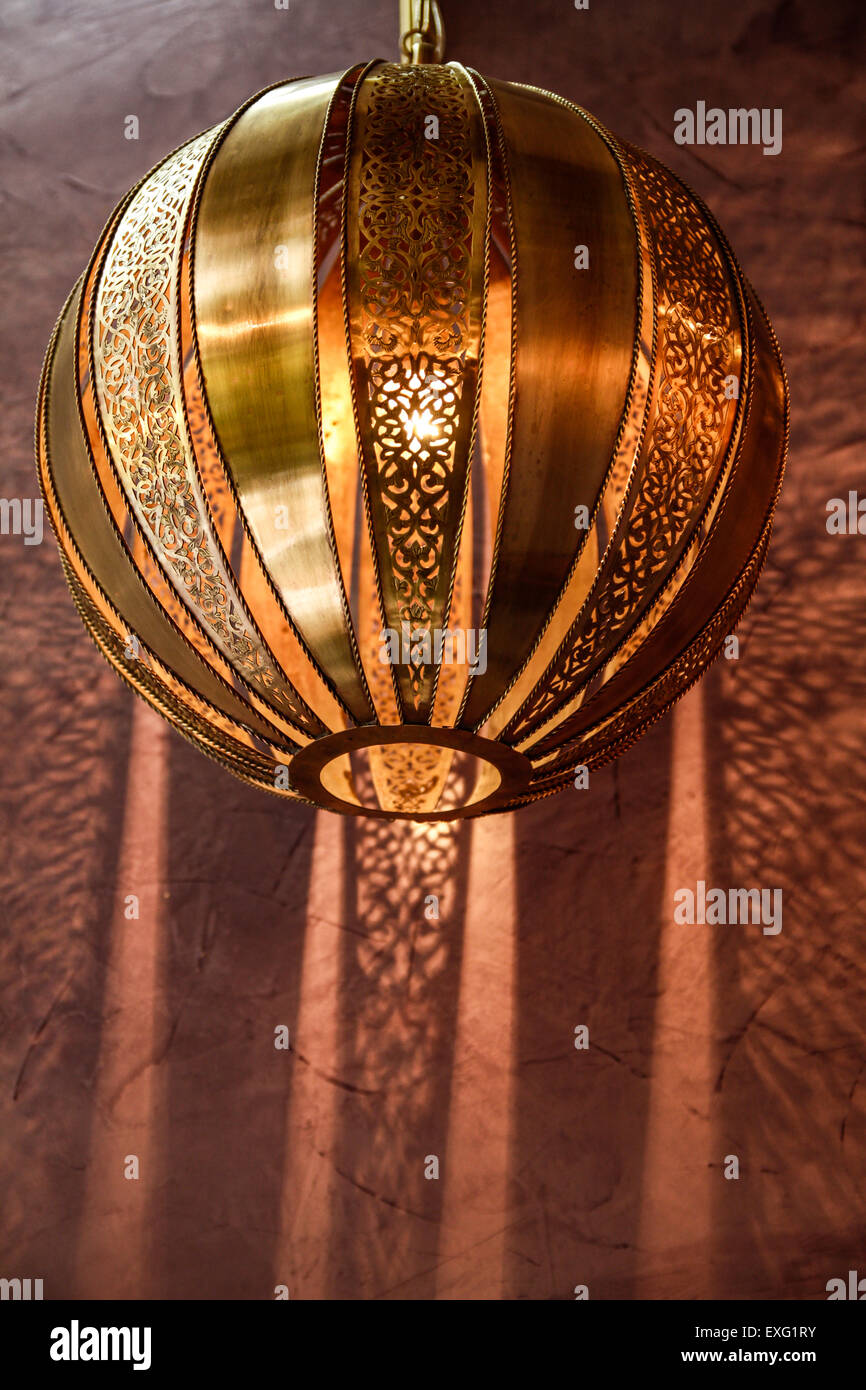 Luminaria Esfera de Cobre Artesanal Marroquí con Efecto de Iluminación de Pared en un Riad en Marrakech Foto de stock