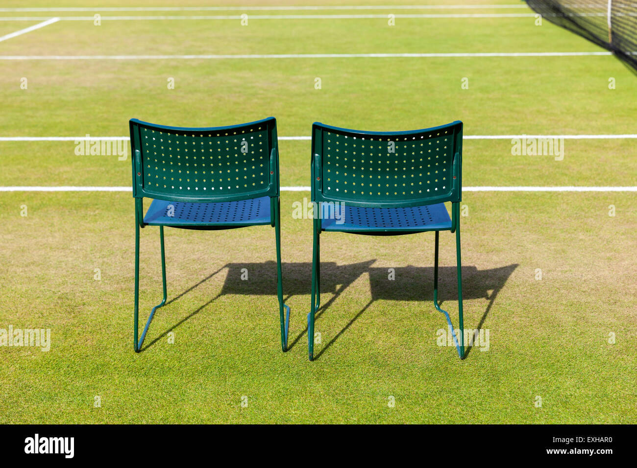 Dos sillas vacías para jugadores en una cancha de césped en el All England Lawn Tennis Club durante el Campeonato de Tenis de Wimbledon, Londres Foto de stock