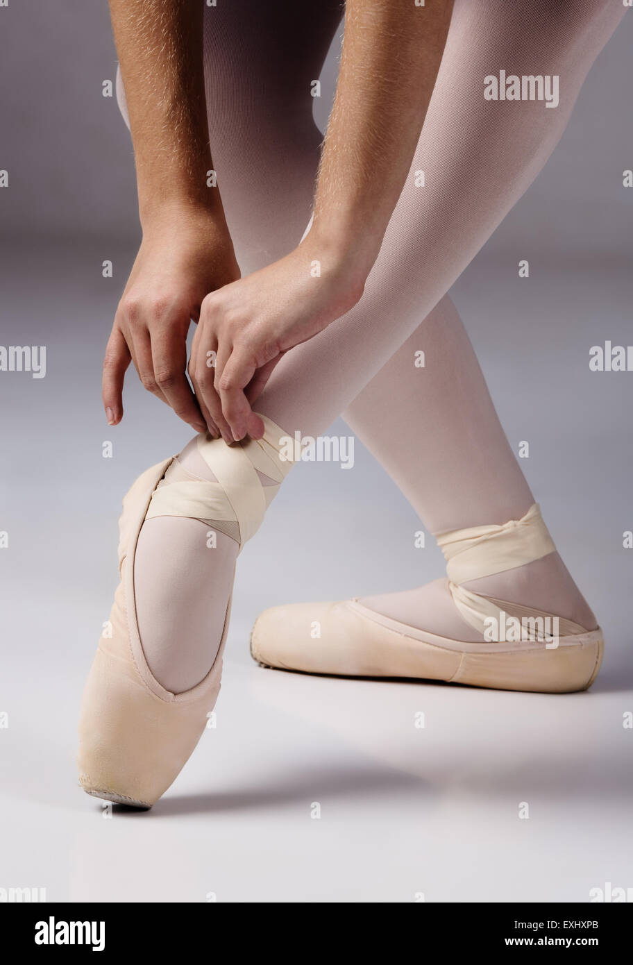 Bailarina de ballet femenino de las cintas de amarre su pointe zapatos  Fotografía de stock - Alamy