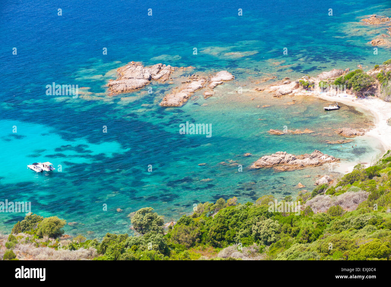 La isla de Córcega, Cupabia golfo. El paisaje costero con un pequeño bote a motor, cerca de la playa rocosa salvaje Foto de stock