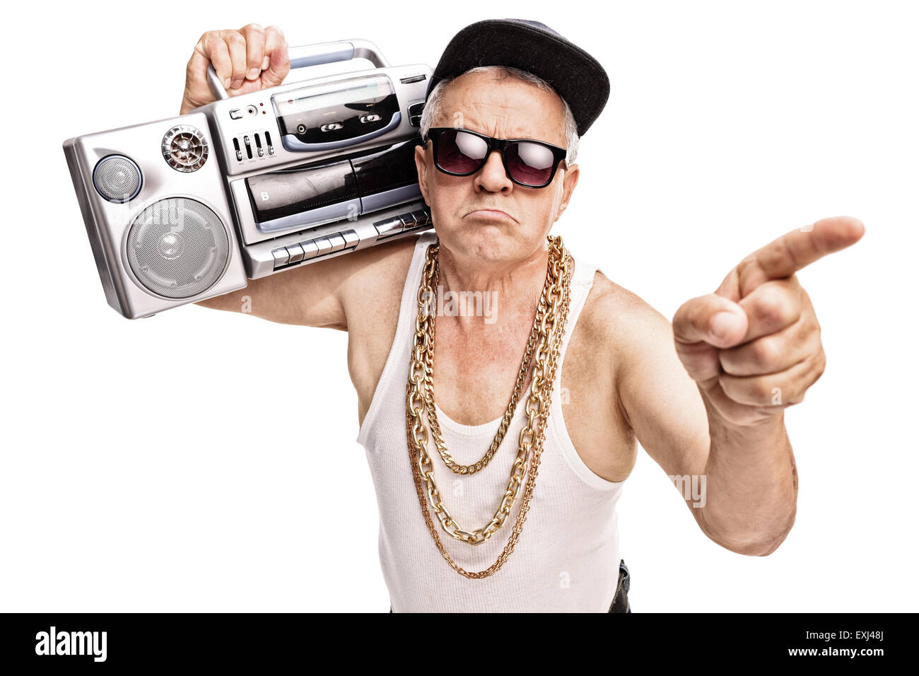 Gruñón rapero senior llevando un ghetto blaster en su hombro y apuntando con su dedo aislado sobre fondo blanco. Foto de stock