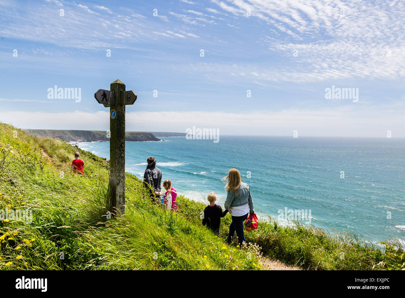 Una familia caminando a lo largo de la ruta costera de Pembrokeshire, Gales Foto de stock
