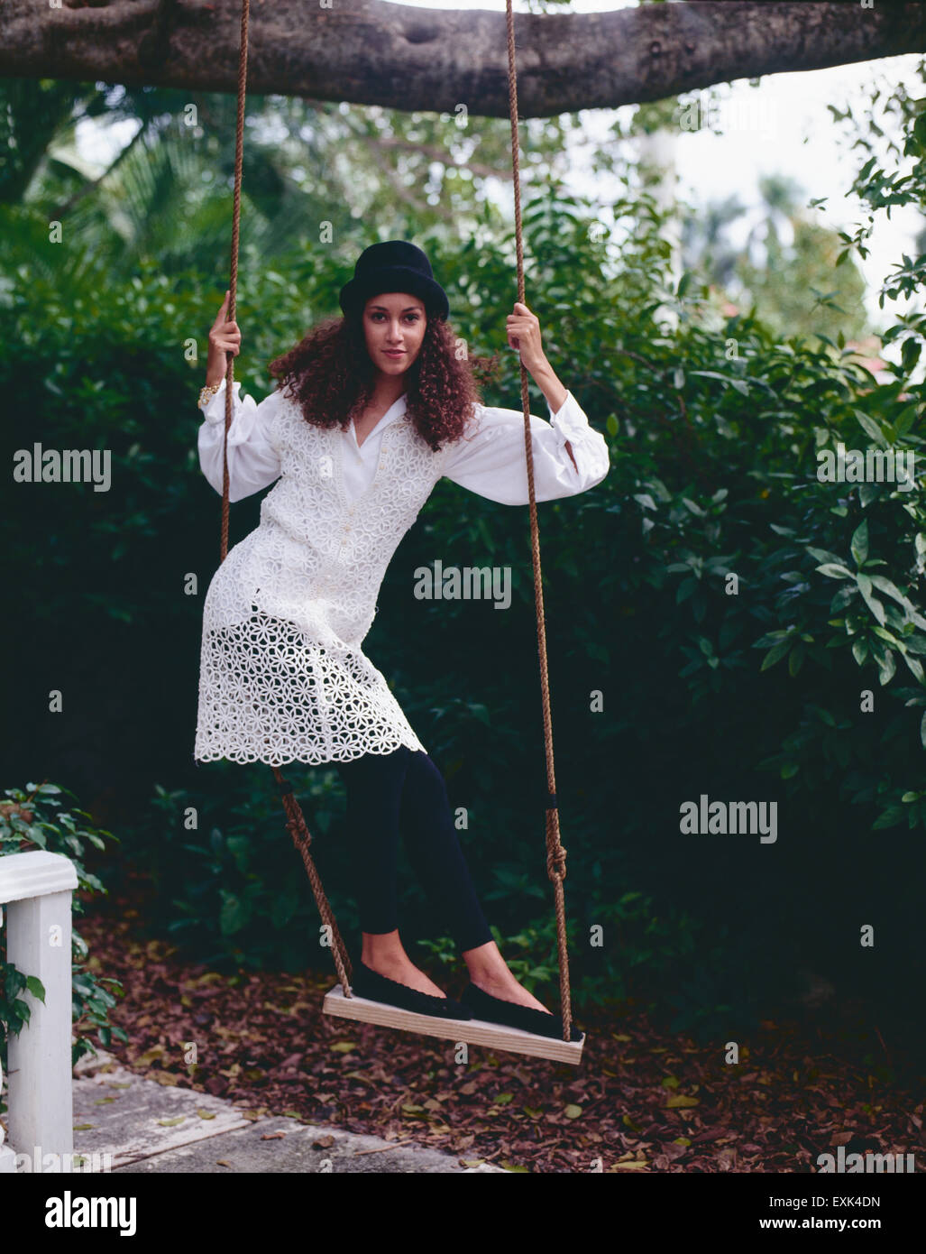 Bonita, joven, divertirse de pie en un columpio Fotografía de stock - Alamy