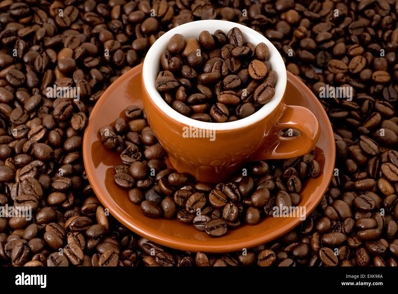 Taza de café llena de granos de café. Foto de stock
