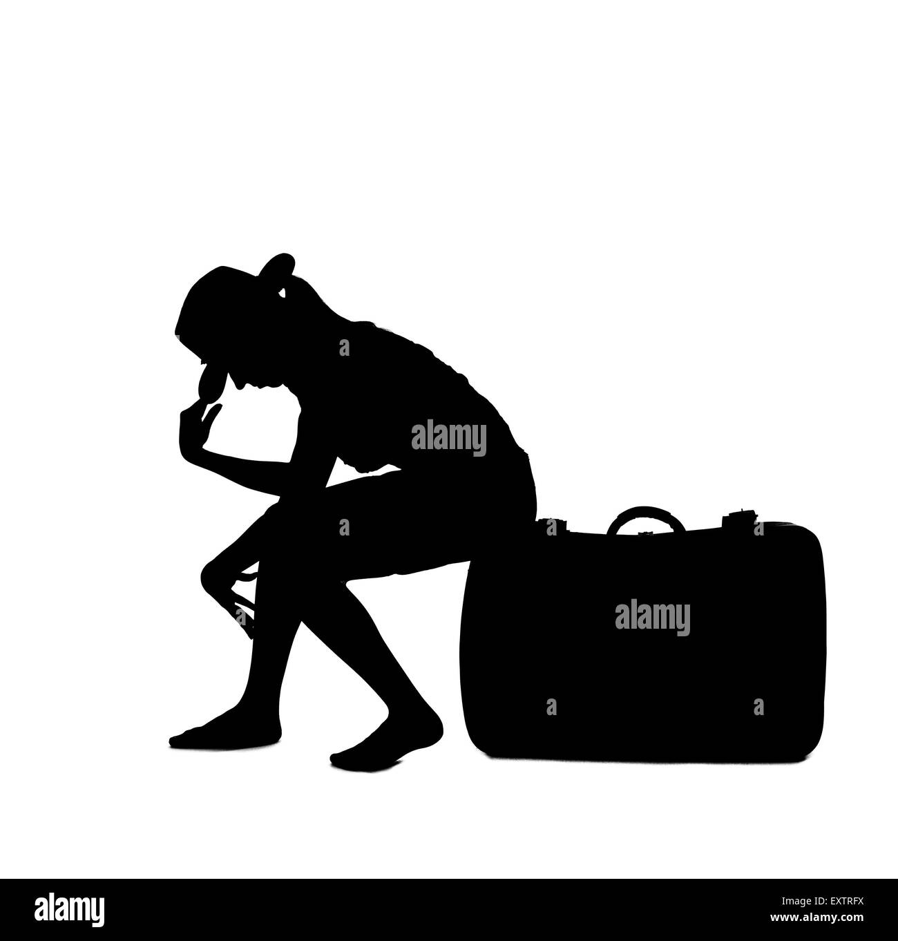 Silueta - mujer sentada sobre el equipaje Foto de stock