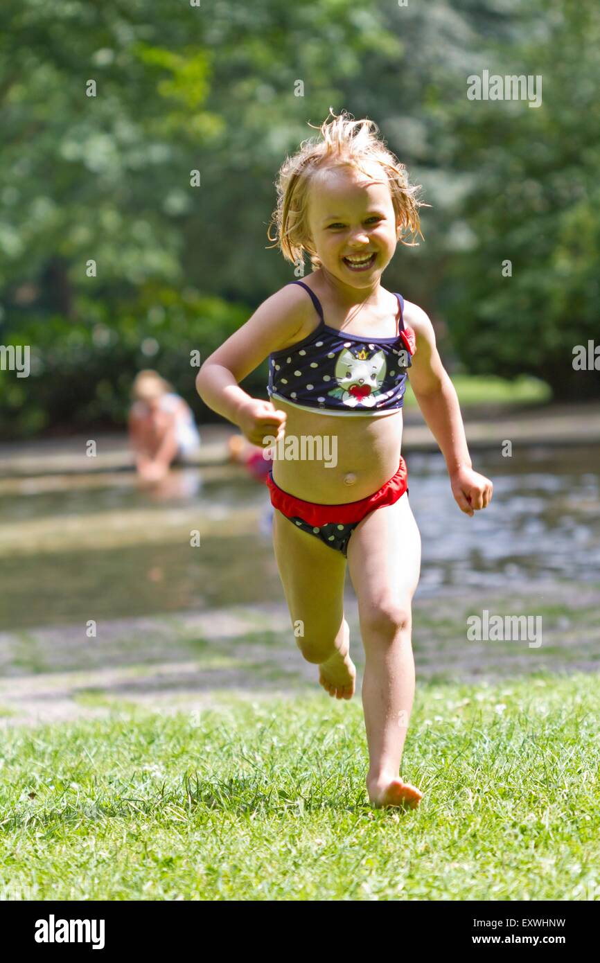 Chica corriendo sobre pradera Foto de stock