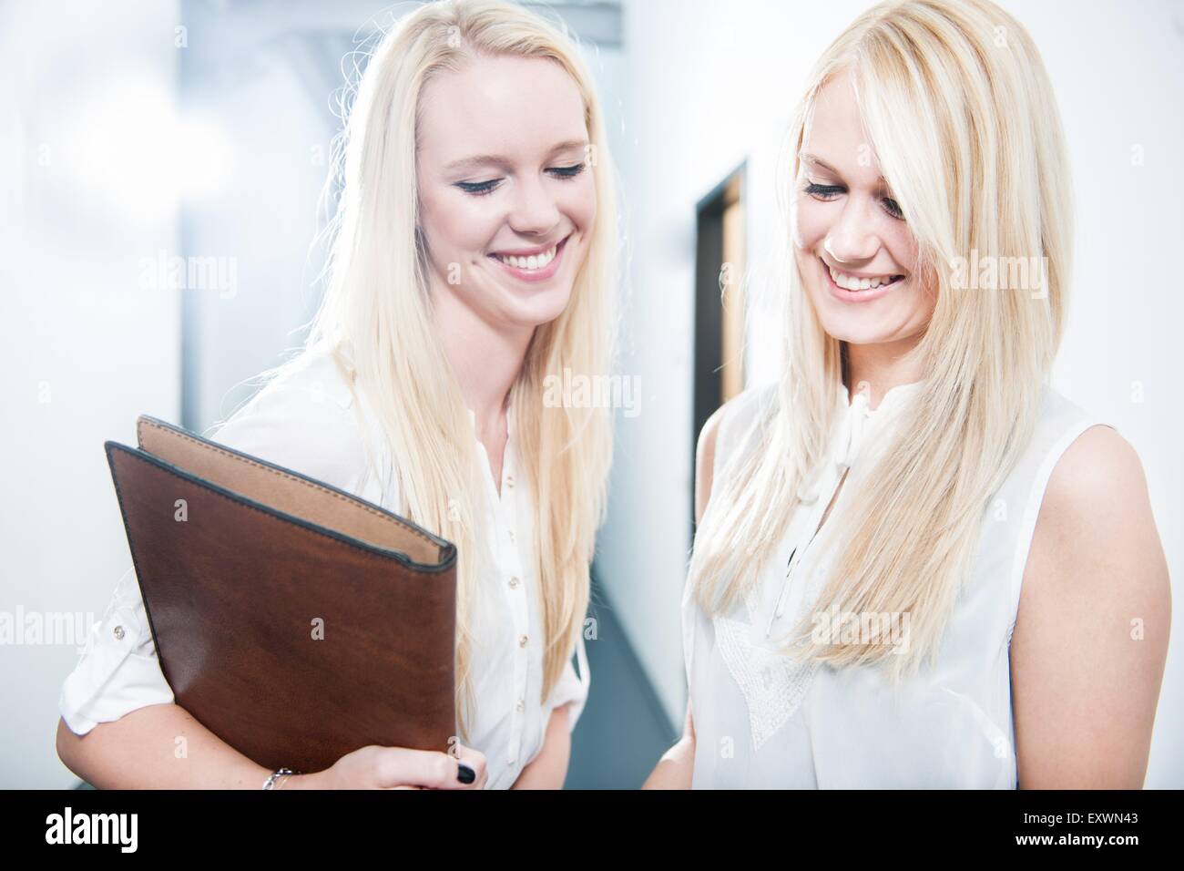 Dos mujeres jóvenes rubios sonrientes en Office Foto de stock