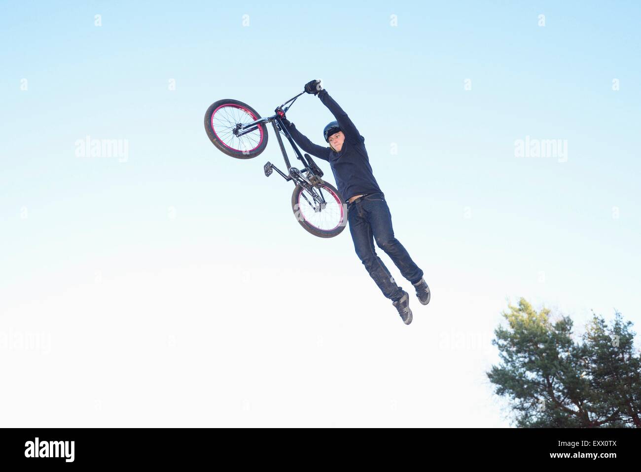 Adolescente saltar en el aire con su bicicleta BMX Foto de stock