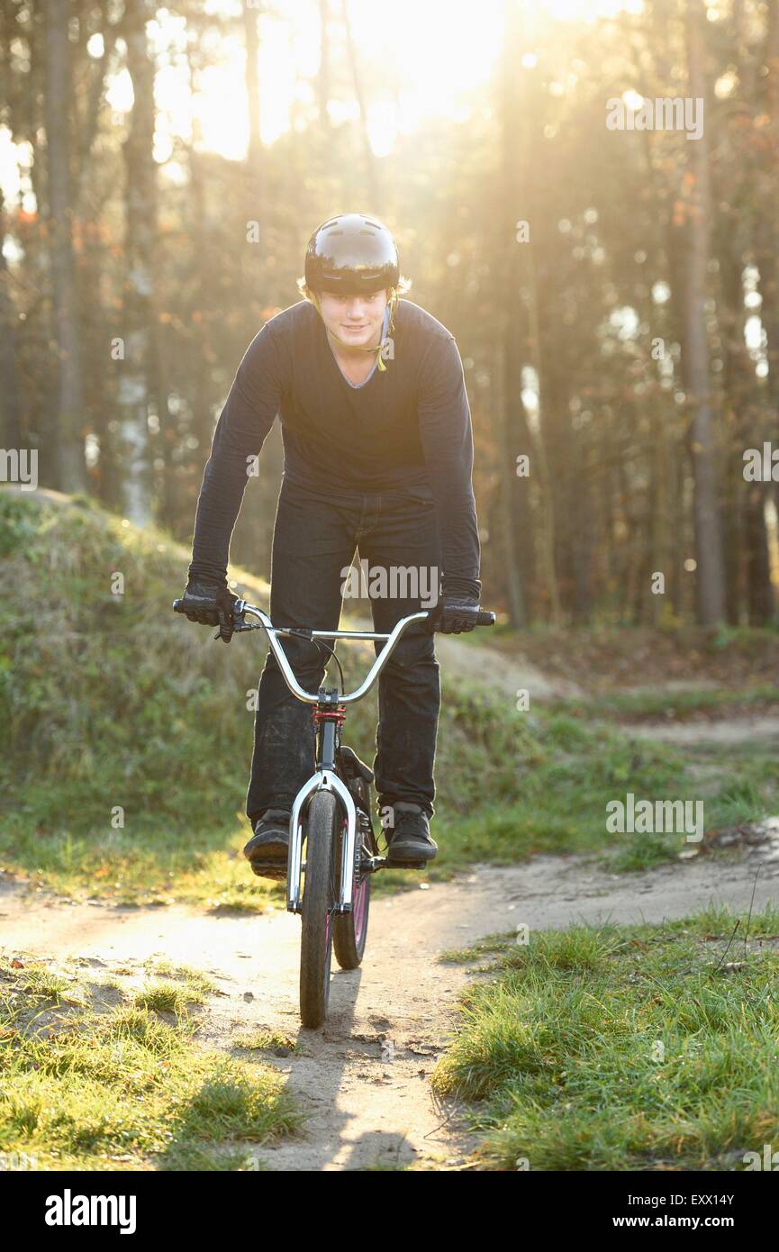 Adolescente con bicicleta BMX en bosque Foto de stock