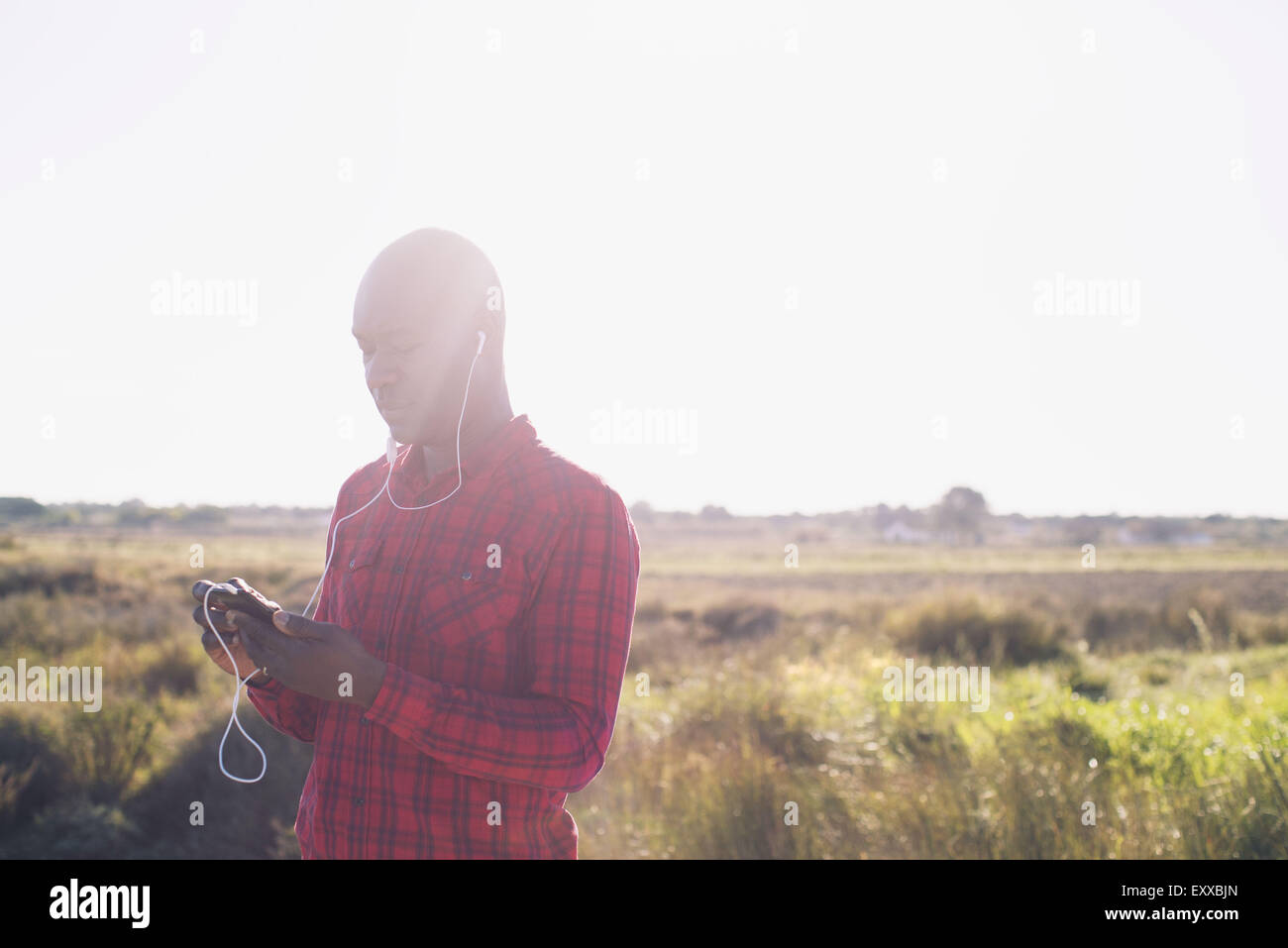 El hombre al escuchar música con auriculares al aire libre Foto de stock