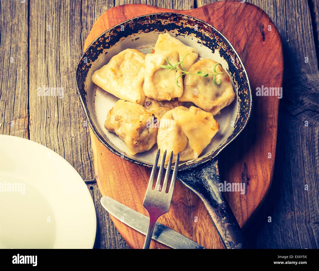 Vintage foto de empanadas fritas con la cebolla en una sartén. Foto de stock