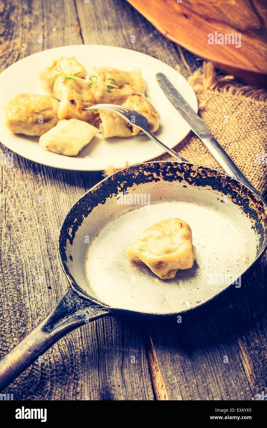 Vintage foto de empanadas fritas con la cebolla en una sartén. Foto de stock