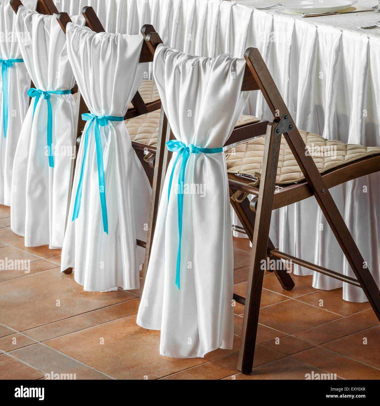 Fila de boda sillas, decorado con tela blanca y cintas azules Fotografía de  stock - Alamy
