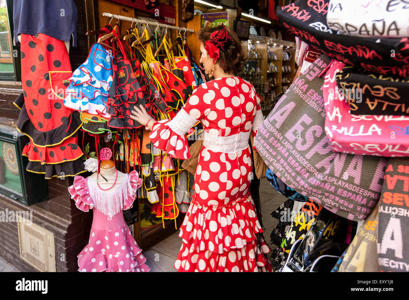 En el tradicional vestido de Sevilla Sevilla mirando a través de la en esta tienda turística en el casco antiguo de Sevilla, Andalucía, España, Euro Fotografía de stock -