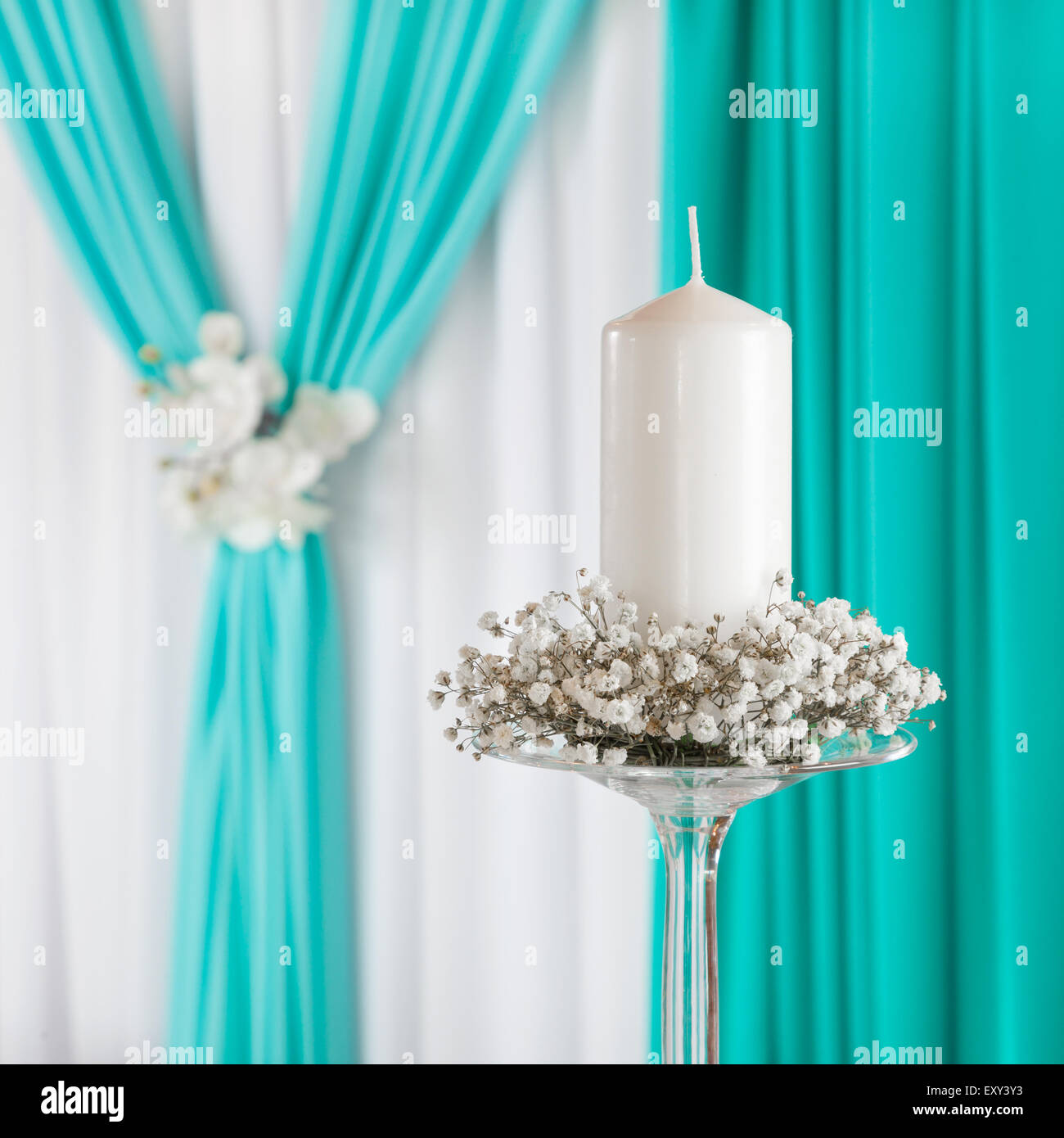 Decoradas cortina y vela en el candelero. Decoración de bodas. Foto de stock